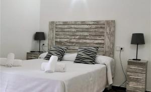 a bedroom with two beds and a wooden headboard at Hotel Rosamar - Emar Hotels in Es Pujols