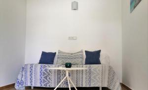 a bed with blue and white pillows and a table at Hotel Rosamar - Emar Hotels in Es Pujols
