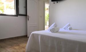 a bedroom with a white bed with towels on it at Hotel Rosamar - Emar Hotels in Es Pujols