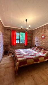 a bedroom with a large bed in a brick wall at La Posada de Gogg Cabañas in Bella Vista