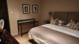 a hotel room with a bed and a desk at Shepherd's Cottage in Nieu-Bethesda