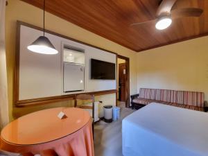 a living room with a table and a couch at APARTAMENTO GRAMADO HOTEL in Gramado