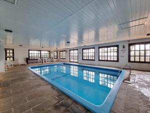 a large swimming pool in a building at APARTAMENTO GRAMADO HOTEL in Gramado