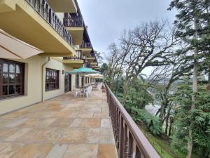 a balcony of a house with a table and chairs at APARTAMENTO GRAMADO HOTEL in Gramado