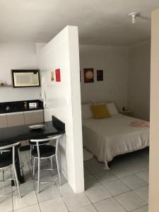 Schlafzimmer mit einem Bett, einem Schreibtisch und einem Tisch in der Unterkunft Apartamento Studio com banheiro privativo in São José