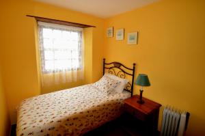 um quarto amarelo com uma cama e uma janela em Juana Quinta em Monte de Breña