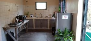 a kitchen with a refrigerator and a sink at Baril O'thentik Gîte et Bungalow in Saint-Philippe