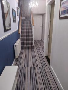 a hallway with a staircase with a carpeted floor at Sea View Cottage, 2 bedrooms with stunning views in Cobh