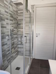 W łazience znajduje się prysznic ze szklanymi drzwiami. w obiekcie Cuscino e Cornetto w mieście Salerno