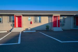 a building with red doors in a parking lot at OYO Hotel Portland OR near Airport in Gresham