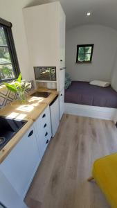 una cucina con letto in una piccola camera di Luxury Shepherds Hut Retreat a Plettenberg Bay