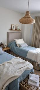 1 dormitorio con 2 camas y luz colgante en Santiago Plaza Departamento Microcentro Premium en Salta