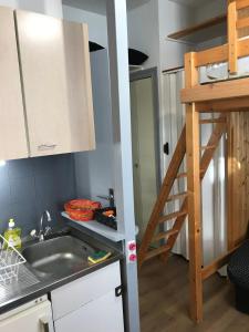 una pequeña cocina con fregadero y escalera en L'Idéal en Charteuse en Saint-Pierre-de-Chartreuse