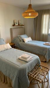 1 dormitorio con 2 camas y lámpara de araña en Santiago Plaza Departamento Microcentro Premium en Salta