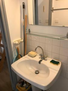 y baño con lavabo blanco y espejo. en L'Idéal en Charteuse en Saint-Pierre-de-Chartreuse