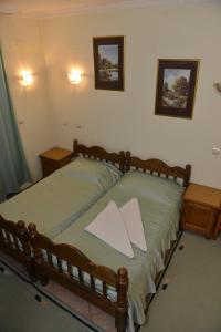 a bedroom with a wooden bed with two pillows on it at Sneža in Apatin