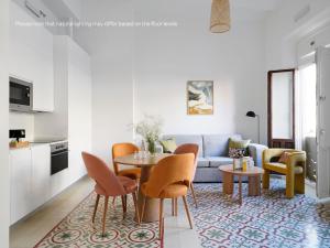 numa I Solea Apartments في إشبيلية: غرفة معيشة مع طاولة وكراسي وأريكة