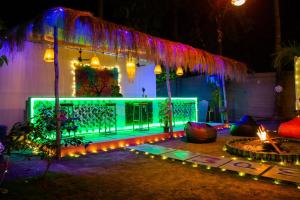 a house decorated with green lights and a fence at BunkNBrew in Palolem