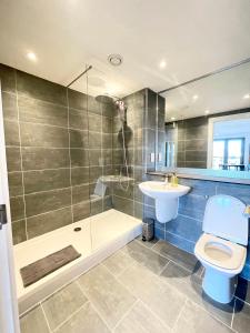 a bathroom with a toilet and a sink and a shower at City centre, Top floor apartment, Two balconies in Manchester +16 photos