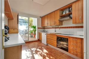 a kitchen with wooden cabinets and white appliances at Los Altos 19 in La Herradura