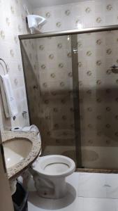 een badkamer met een toilet en een glazen douche bij Apartamento dunas cabo frio in Cabo Frio