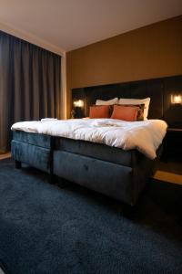 sypialnia z dużym łóżkiem z pomarańczowymi poduszkami w obiekcie Hotel Lowietje Lisse - Keukenhof w mieście Lisse