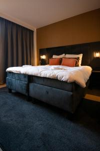 a bedroom with a large bed with orange pillows at Hotel Lowietje Lisse - Keukenhof in Lisse