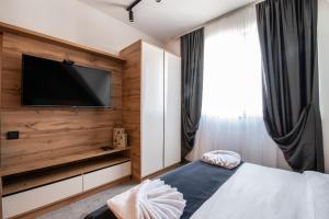 a bedroom with a flat screen tv and a bed at Hotel Djina - Kopaonik in Kopaonik