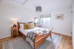a bedroom with a bed with a table and a window at Solebay House in Woodbridge