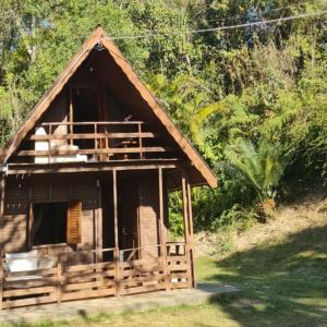 a small house with a thatched roof on a hill at Sitio Arco Iris da Lia in São Roque