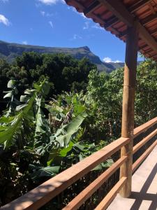 a wooden porch with a view of the mountains at Chalés Cristal - Vale do Capão in Palmeiras
