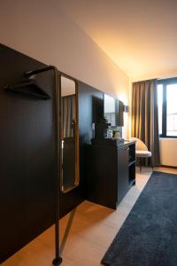 een hotelkamer met een spiegel en een televisie bij Hotel Lowietje Lisse - Keukenhof in Lisse