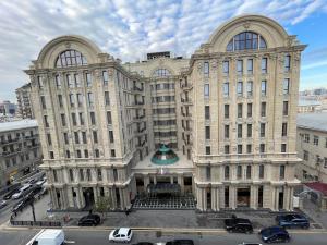 un gran edificio con coches estacionados frente a él en Continental apartment, en Baku