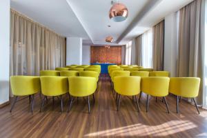 Lordos Beach Hotel & Spa في لارنكا: قاعة اجتماعات مع كراسي صفراء وطاولة