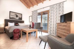 Schlafzimmer mit einem Bett, einem TV und einem Tisch in der Unterkunft Hotel-Gasthof Im Wiesengrund in Bad Hindelang