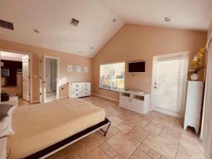 a large bedroom with a bed and a television at SWISS 105 - Lake Olsen in Clermont