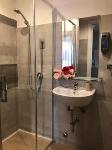 a bathroom with a sink and a shower with a glass door at B&B Andy&LU in Rome