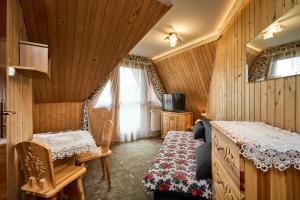 ザコパネにあるZakopiankaのベッド、テーブル、椅子が備わる客室です。