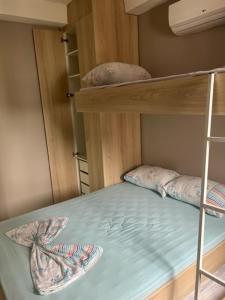 a wooden bunk bed with two pillows on the bottom bunk at Apes Enseada Guarujá in Guarujá