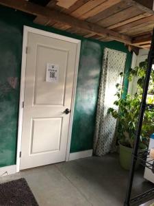 a white door in a room with a plant at The Schoolhouse vintage home on the farm 