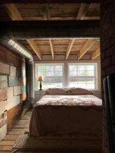 a bedroom with a bed in a room with a window at The Schoolhouse vintage home on the farm 