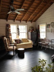 a living room with a couch and a ceiling fan at The Schoolhouse vintage home on the farm 