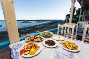 una mesa con platos de comida en la playa en Villa Alexandra, en Póros