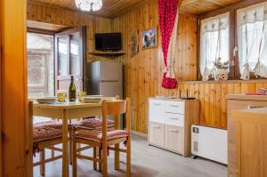 cocina con mesa, sillas y nevera en Maison Rhémy - Relax e montagne, en Saint-Rhémy-en-Bosses