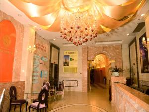 una hall con lampadario pendente, tavolo e sedie di Guangzhou Pengman Apartment Zhengjia Huanshi Branch a Canton