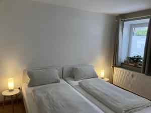 two beds in a room with two lights on them at Enz in Bietigheim-Bissingen