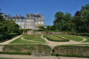 a garden in front of a large building at Le Joffre - sur le port - wifi in Vannes