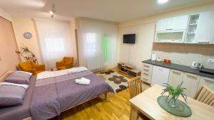 ノヴィ・パザルにあるPaspalj Apartmanのベッド2台、テーブル、キッチンが備わる客室です。
