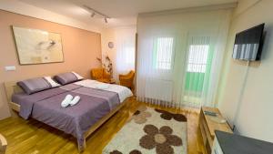 - une chambre dotée d'un lit avec deux chaussures blanches dans l'établissement Paspalj apartman, à Novi Pazar