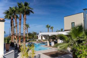 a resort with palm trees and a swimming pool at Insulae Resort in Cefalù
